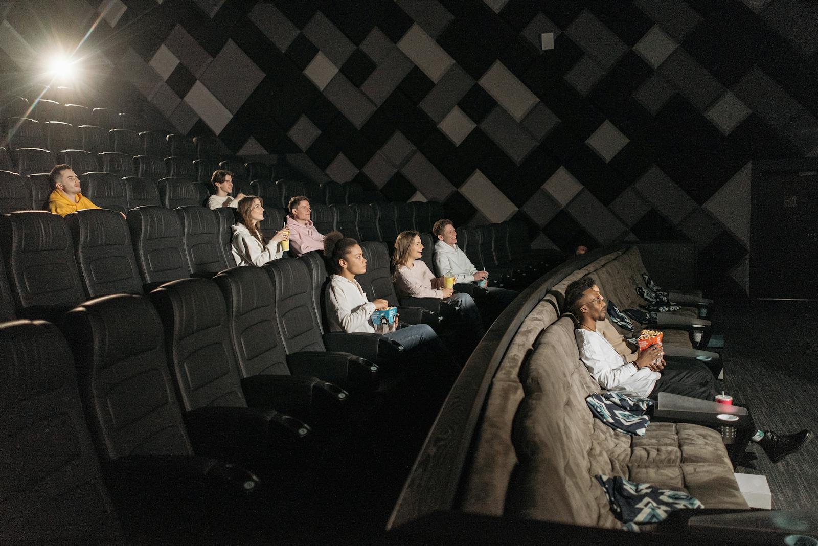 Audience enjoying a film screening in a modern theater with popcorn and drinks.